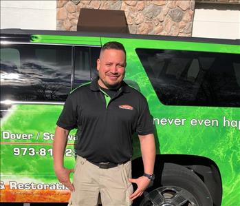 male posing in black servpro shirt in front of a truck