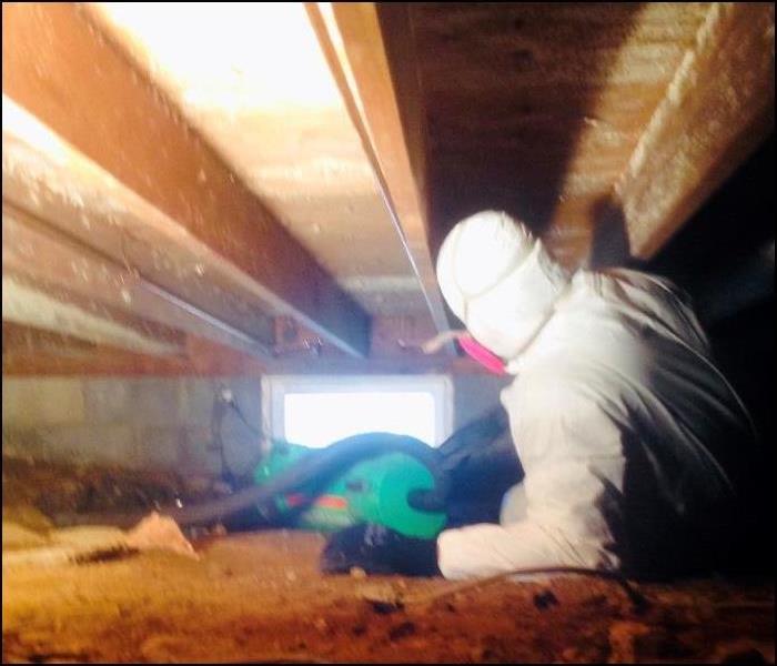 employee in PPE in a crawlspace
