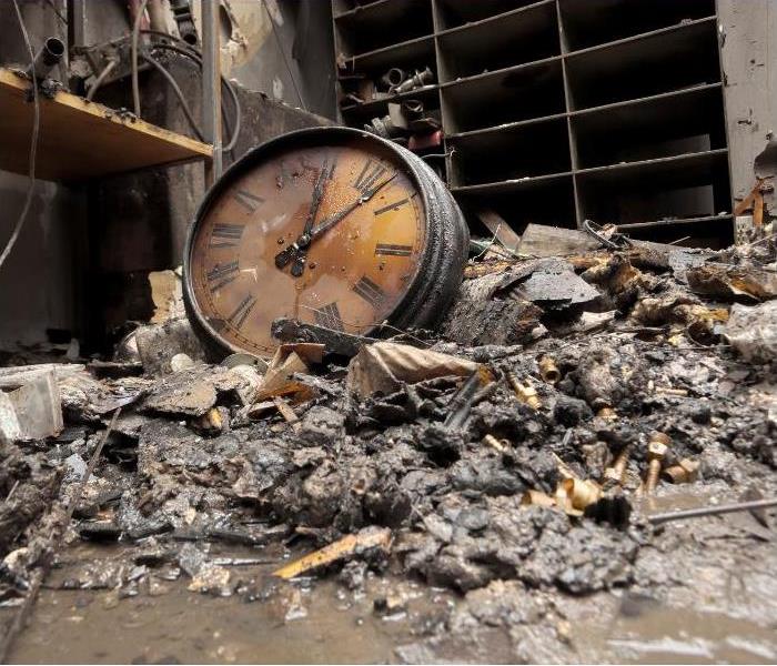 fire damaged clock on a pile of debris